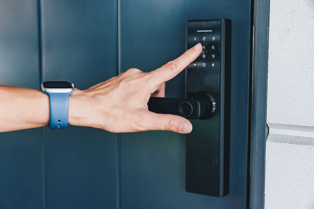 Woman's hand opening and closing the house with fingerprint scan. NFC Technology, keycard, PIN number, Fingerprint scan, smartphone, electrical and contactless concepts